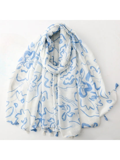 Scarvii scarf draped over a chair highlighting lightweight fabric and tassel details