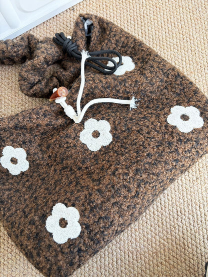 Cosbai knit shoulder bag with floral design hanging on chair back