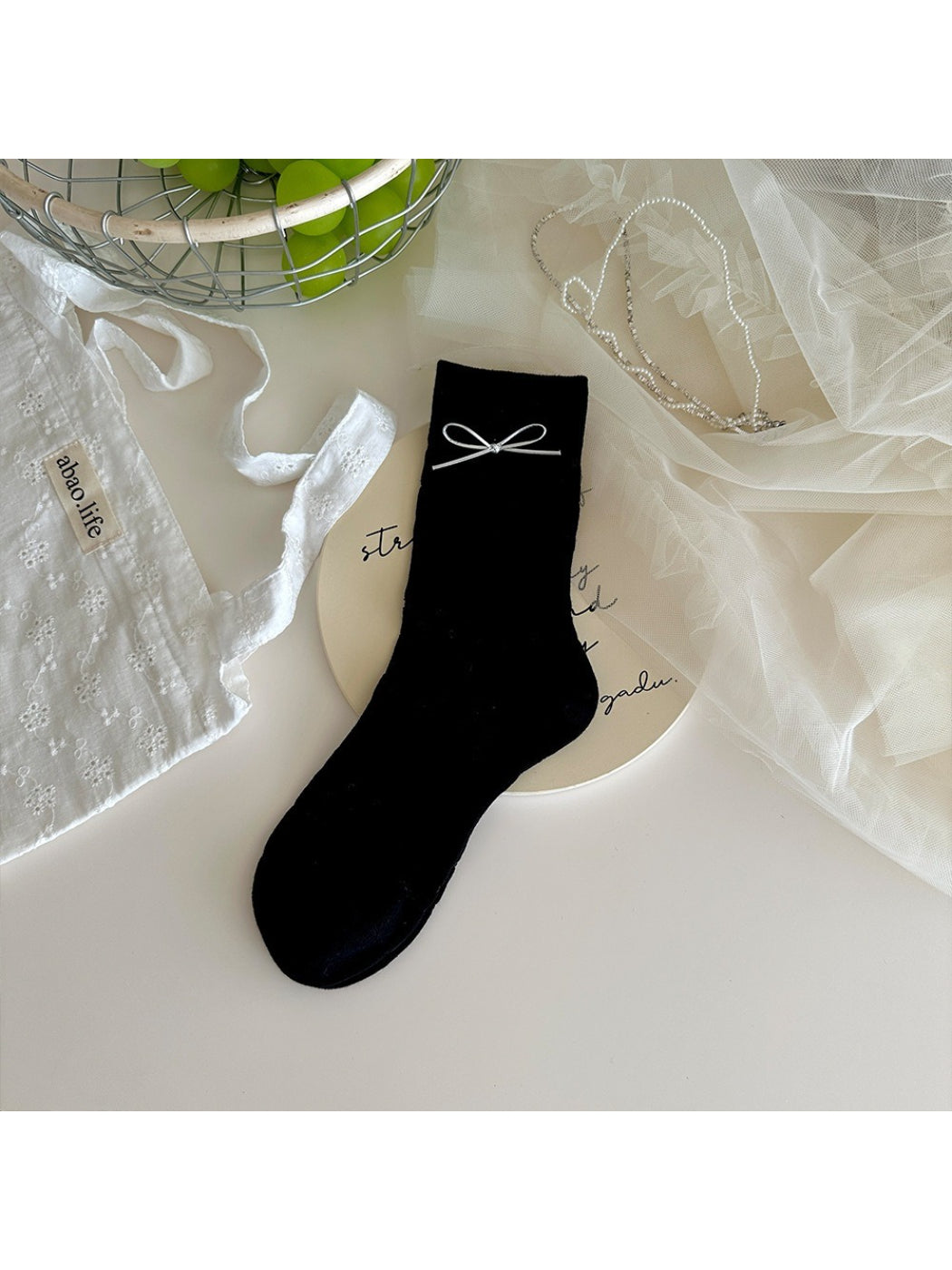 Flat lay of Rufia socks displaying bow embellishment and knit pattern