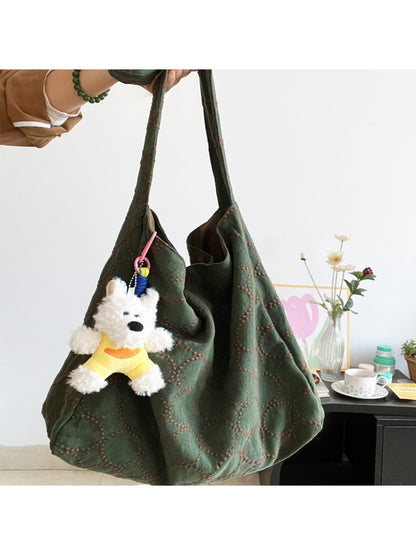 Close-up of beige Cosbai tote bag showing textured material and dog charm detail