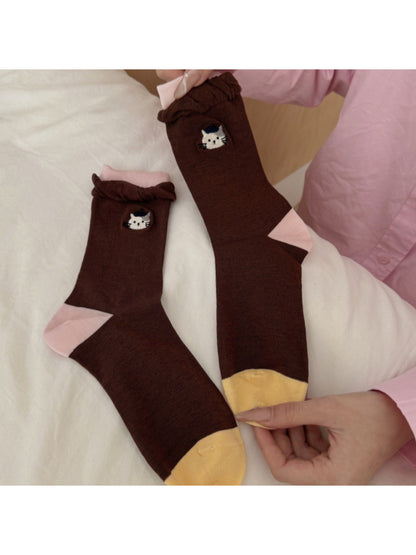 Close-up of sock fabric texture and black cat design on twisted cuff socks