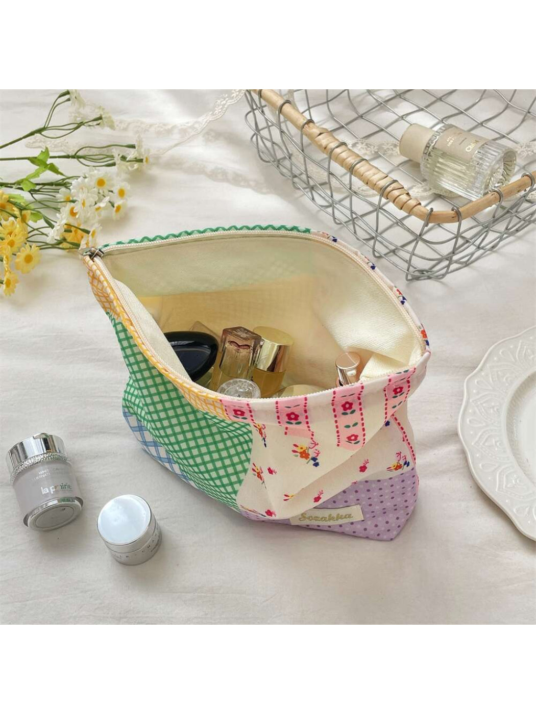 Cosbai patchwork check cosmetic pouch placed next to makeup brushes and lipstick
