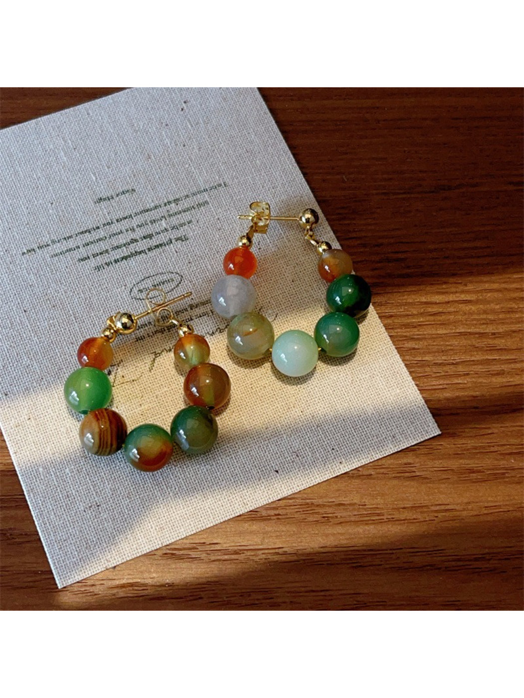 Earwish multicolor beaded hoop earrings shown from a side angle highlighting bead details