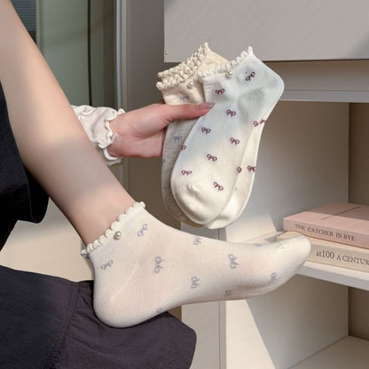 Pair of Rufia bow motif no show socks in light beige color displayed flat