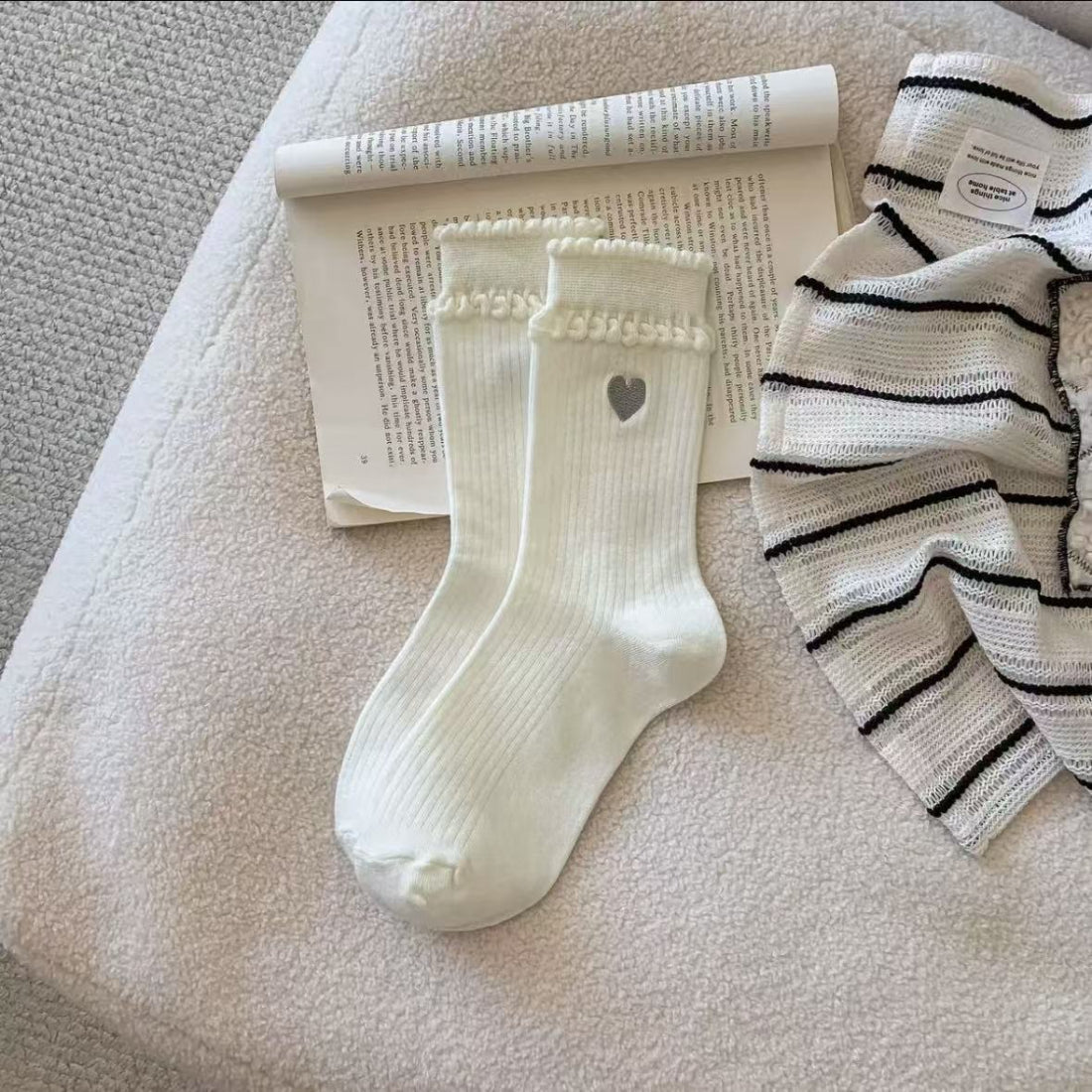 Side view of Rufia crew socks highlighting embroidered heart on ankle area