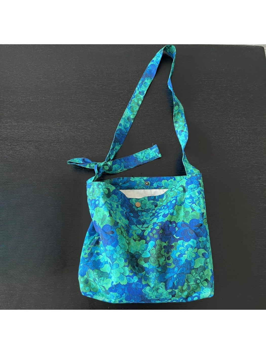 Cosbai blue floral shoulder bag worn over shoulder on model