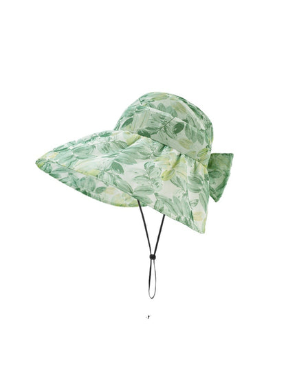 Model wearing Haila garden print shade hat outdoors in a garden setting