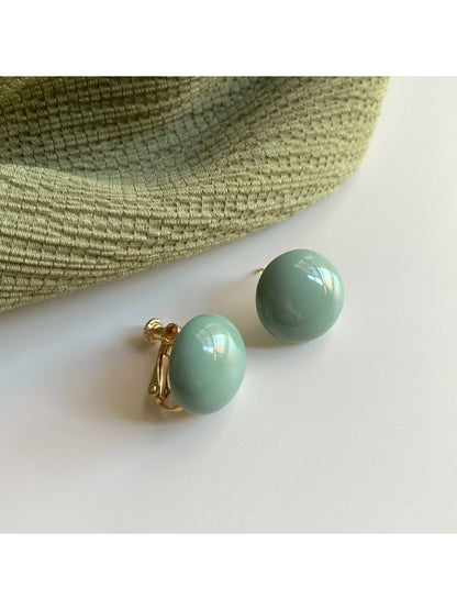 Glossy round stud earrings with a smooth, shiny surface on a white background