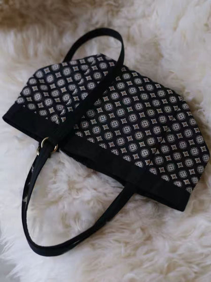 Cosbai black tile pattern tote bag with handles visible against plain backdrop