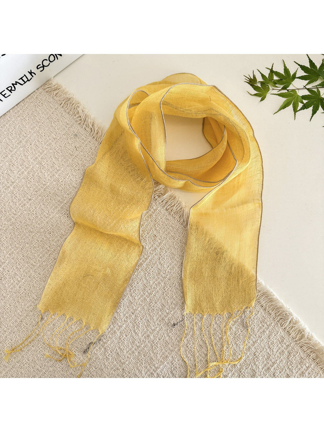 Model with sheer solid summer scarf tied in a casual knot over a white top