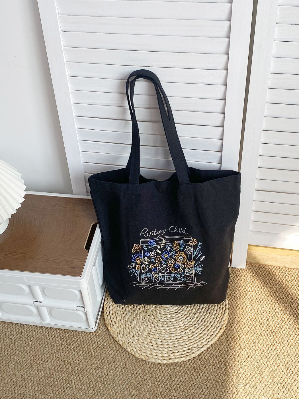 Cosbai tote bag held by model, displaying floral artwork