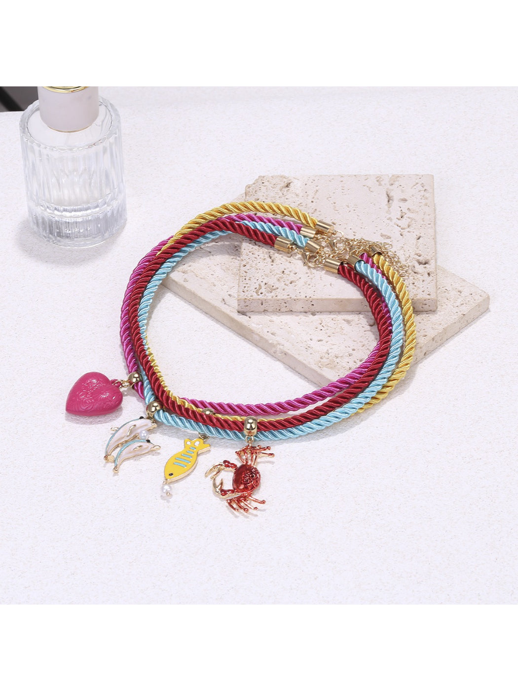 Colorful rope necklace with ocean charms worn on a mannequin bust