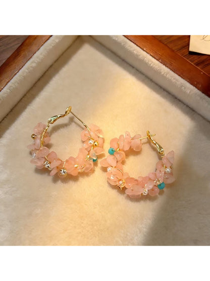 Close-up of Earwish light tone floral hoop earrings on white background