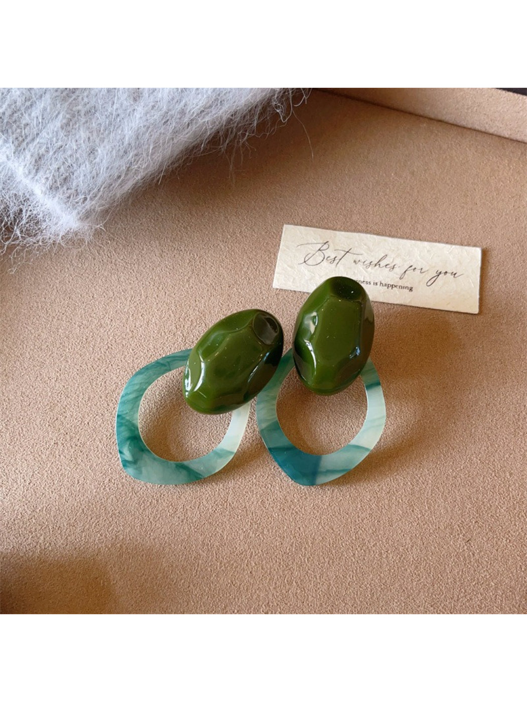 Earwish Color Block Oval Link Earrings hanging on a jewelry stand with a blurred background