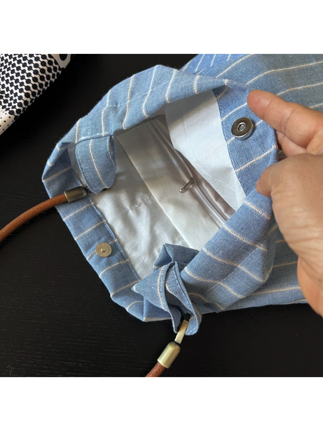 Cosbai blue stripe slouch shoulder bag displayed on a wooden surface with lighting