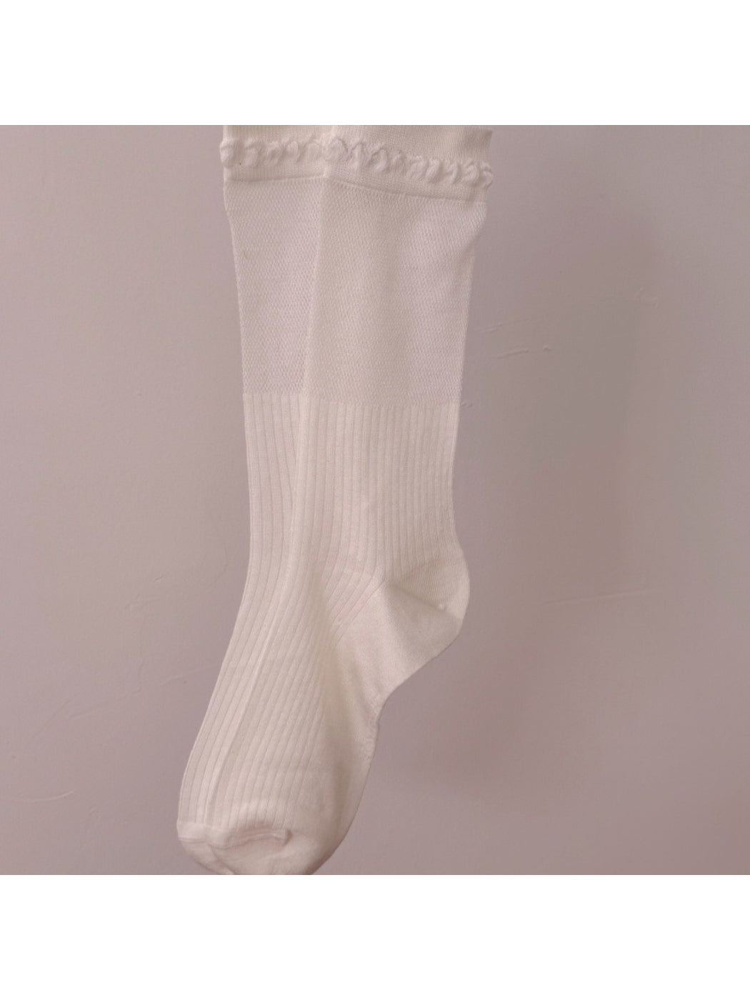 Side view of Rufia beige ribbed crew socks highlighting loop trim