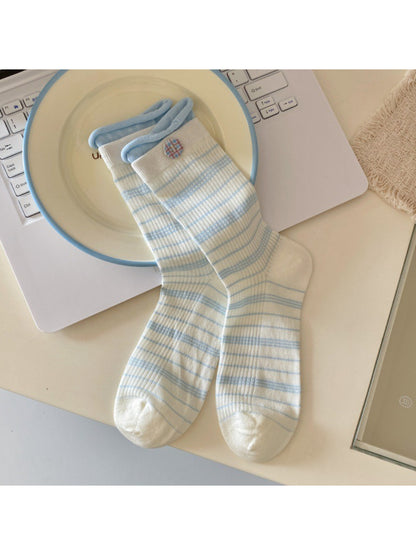 Side view of Rufia beige ribbed socks showing button accents