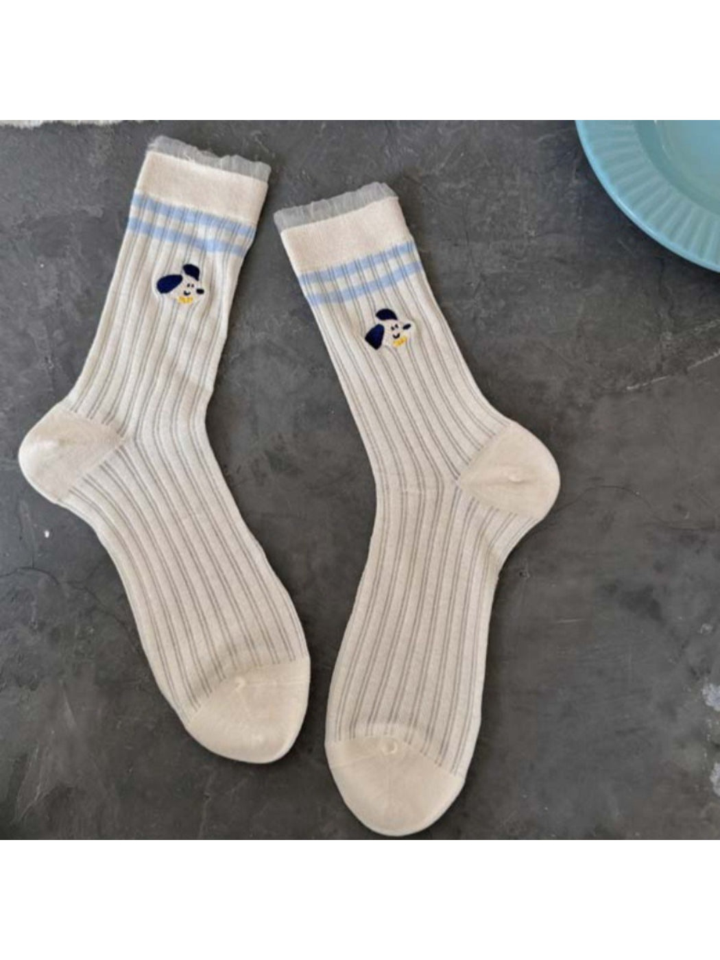 Rufia Playful Pup socks worn by person sitting with legs crossed