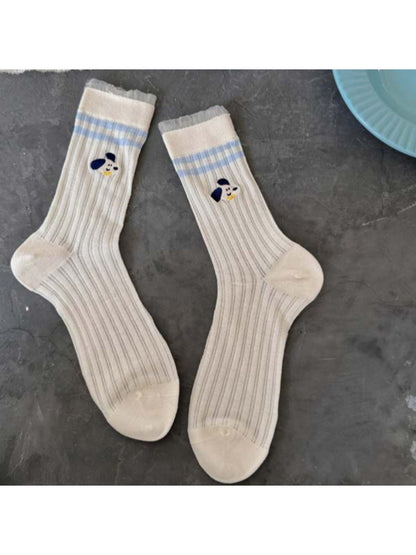 Rufia Playful Pup socks worn by person sitting with legs crossed