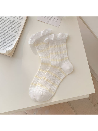 Rufia summer crew socks in pastel colors with striped pattern and frill cuff on wooden surface