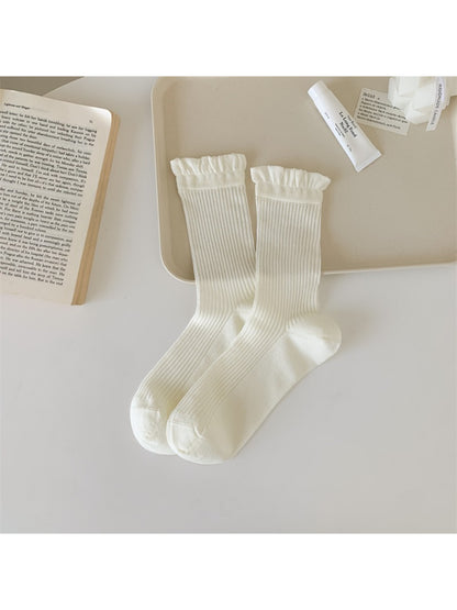 Multiple pairs of Rufia Everyday Ruffle Cuff Crew Socks in various pastel colors stacked