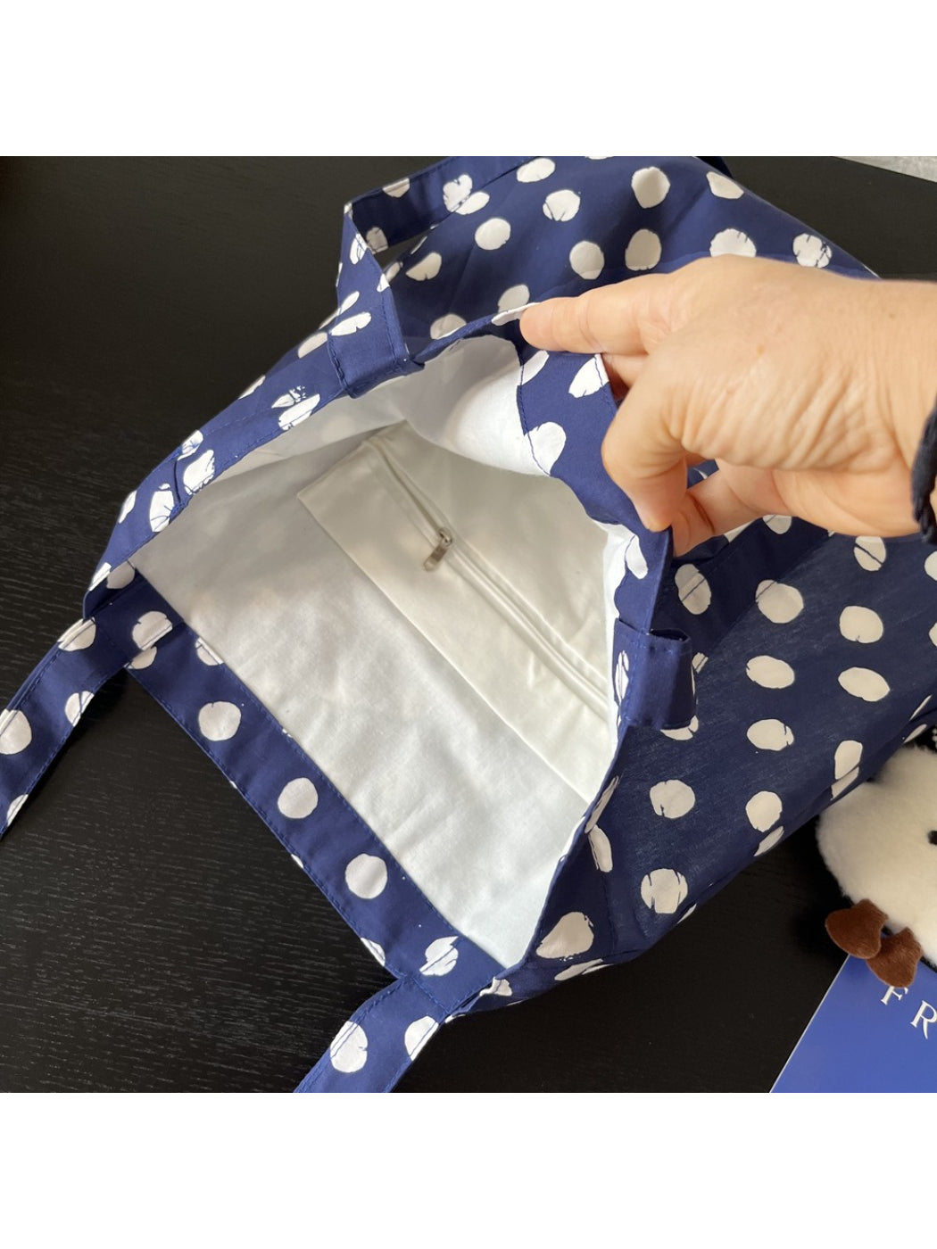 Cosbai navy polka dot tote bag displayed with matching accessories on wooden surface