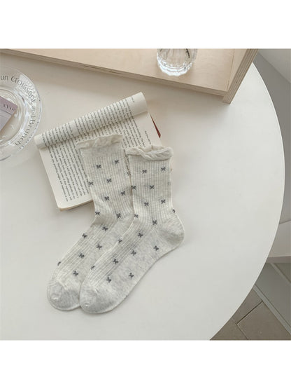 Model wearing Rufia rib crew socks with subtle bow pattern paired with casual shoes
