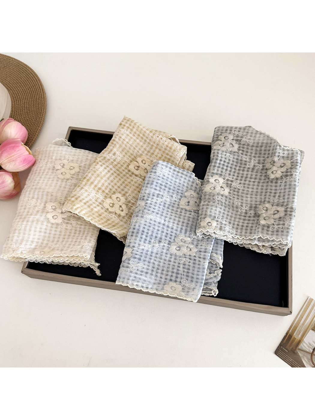 Ivory, beige, light blue, and gray floral-check scarves folded together