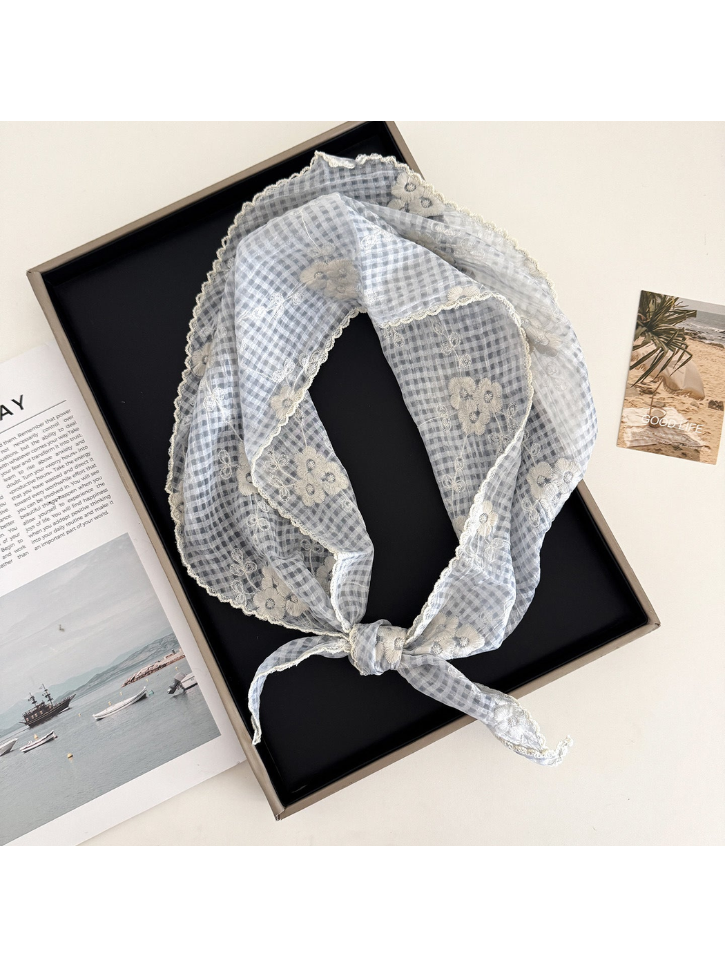 Light blue floral-check triangle scarf arranged in a loop