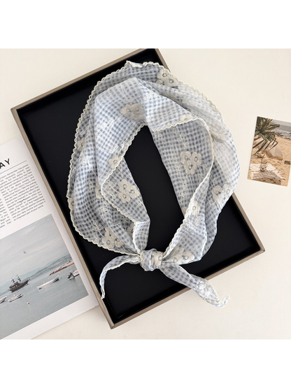 Light blue floral-check triangle scarf arranged in a loop
