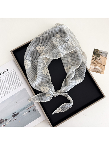 Light gray floral-check triangle scarf arranged in a loop