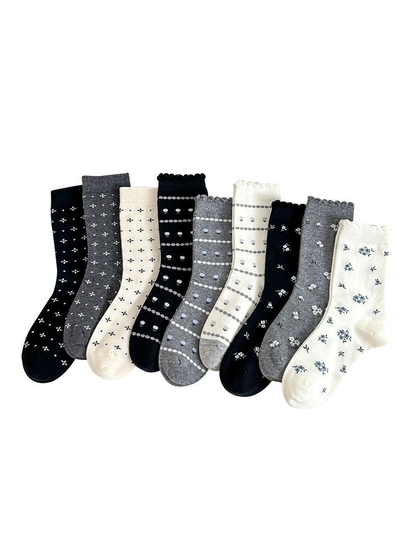 Multiple crew socks in black, gray, cream, and beige patterns displayed together