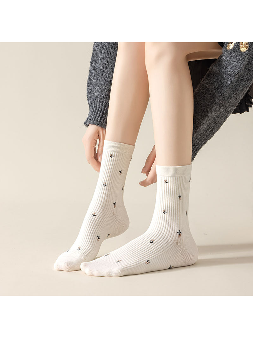 White ribbed crew socks with multicolor motifs worn on feet