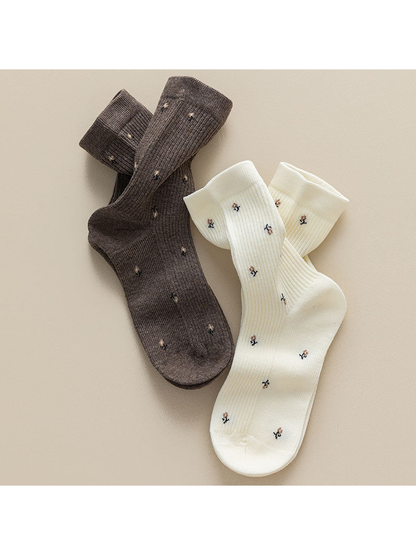 Brown and ivory ribbed crew socks with multicolor motifs displayed together