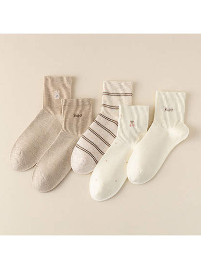 Five neutral crew socks with lettering, rabbit, cherry, and stripe motifs