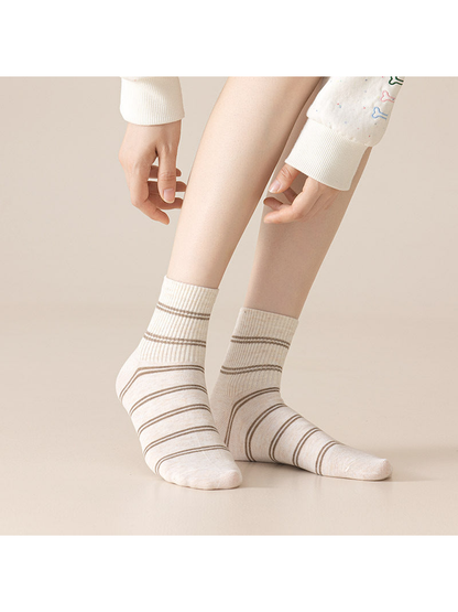 Cream crew socks with brown horizontal stripes worn on legs