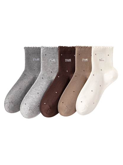 Five neutral-color crew socks lined up together with scattered dot motifs