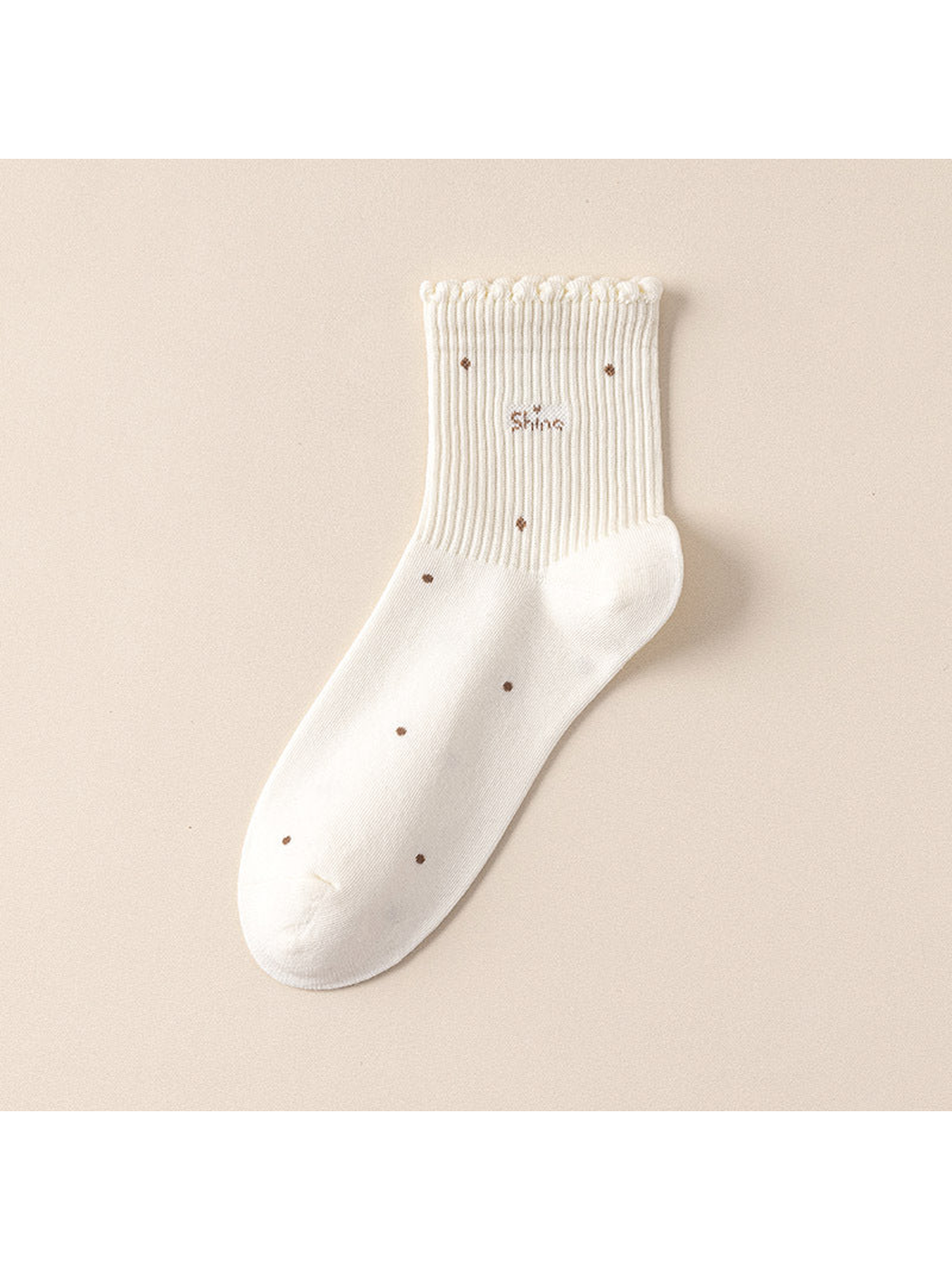 White crew sock with scattered dot motifs and a scalloped ribbed cuff