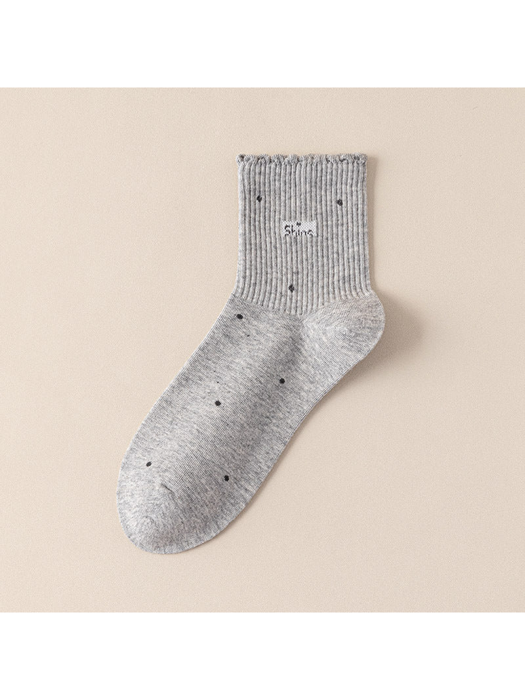 Light gray crew sock with scattered dot motifs and a scalloped ribbed cuff