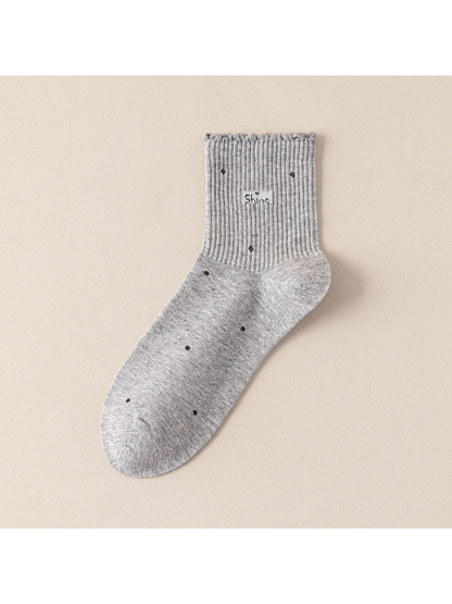 Light gray crew sock with scattered dot motifs and a scalloped ribbed cuff