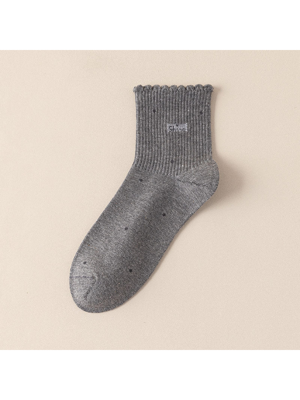 Gray crew sock with scattered dot motifs and a scalloped ribbed cuff
