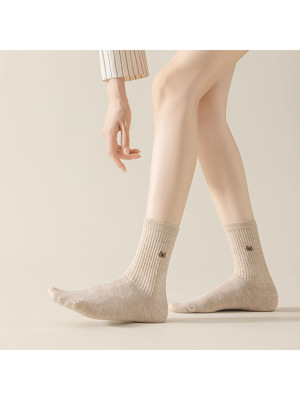 Mottled crew socks worn with one foot extended, showing ribbed legs and small cat motifs