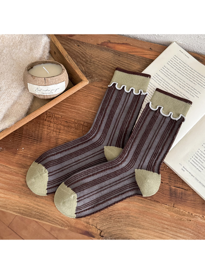 Brown striped socks with pale green cuffs, toe and heel panels, and white wavy cuff trim