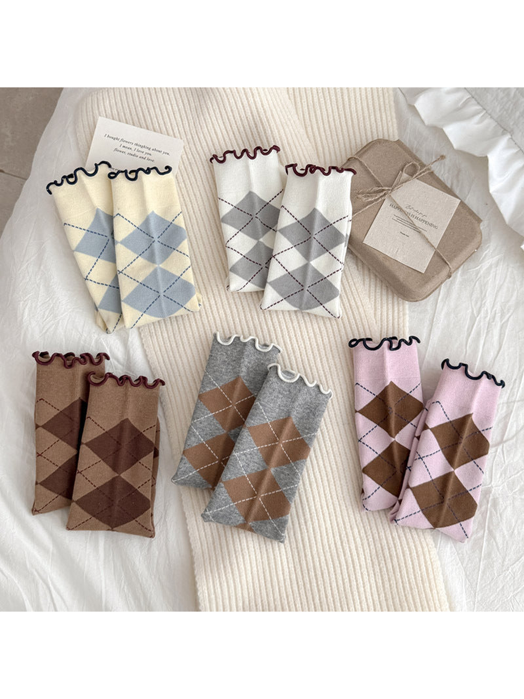 Five colors of argyle socks folded to display their diamond patterns and wavy cuffs