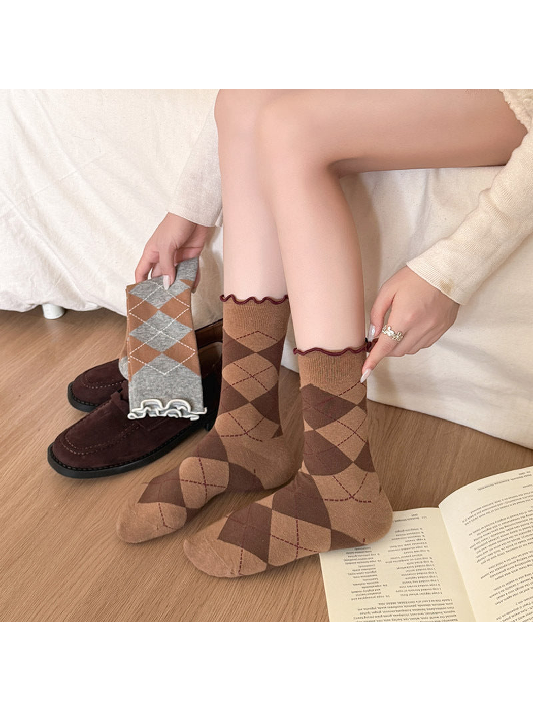 Coffee argyle socks worn without shoes while Heather Gray socks are held beside them