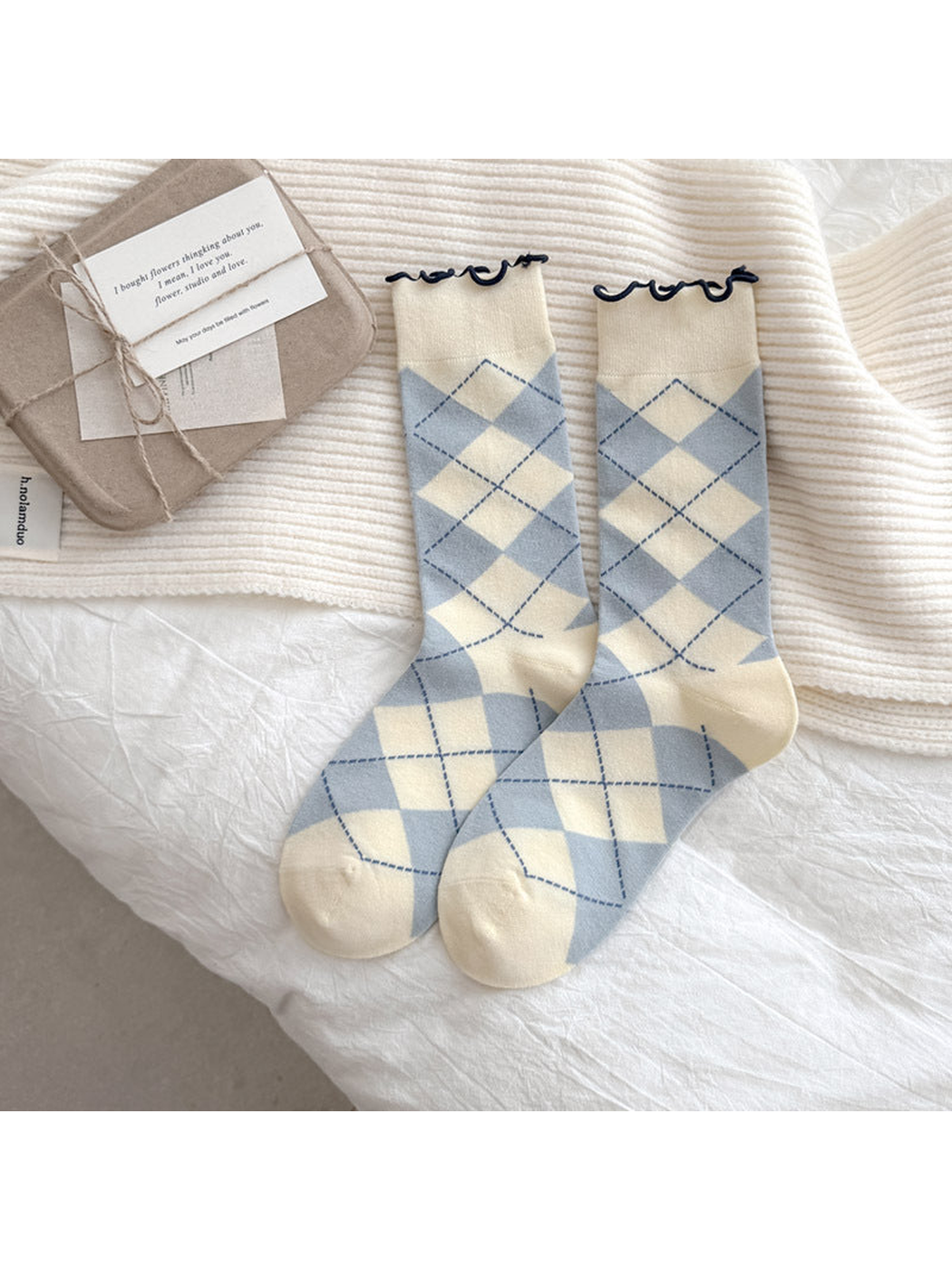 Cream socks with light blue argyle diamonds and dark blue wavy cuffs