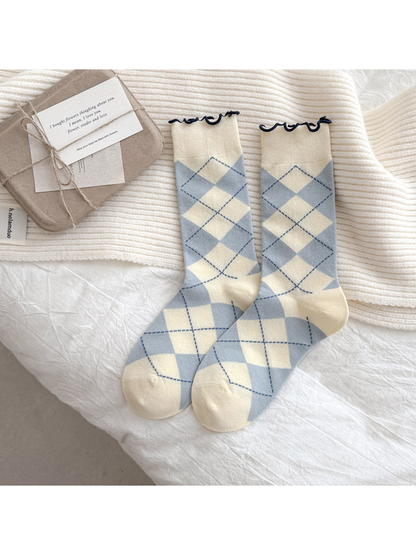 Cream socks with light blue argyle diamonds and dark blue wavy cuffs