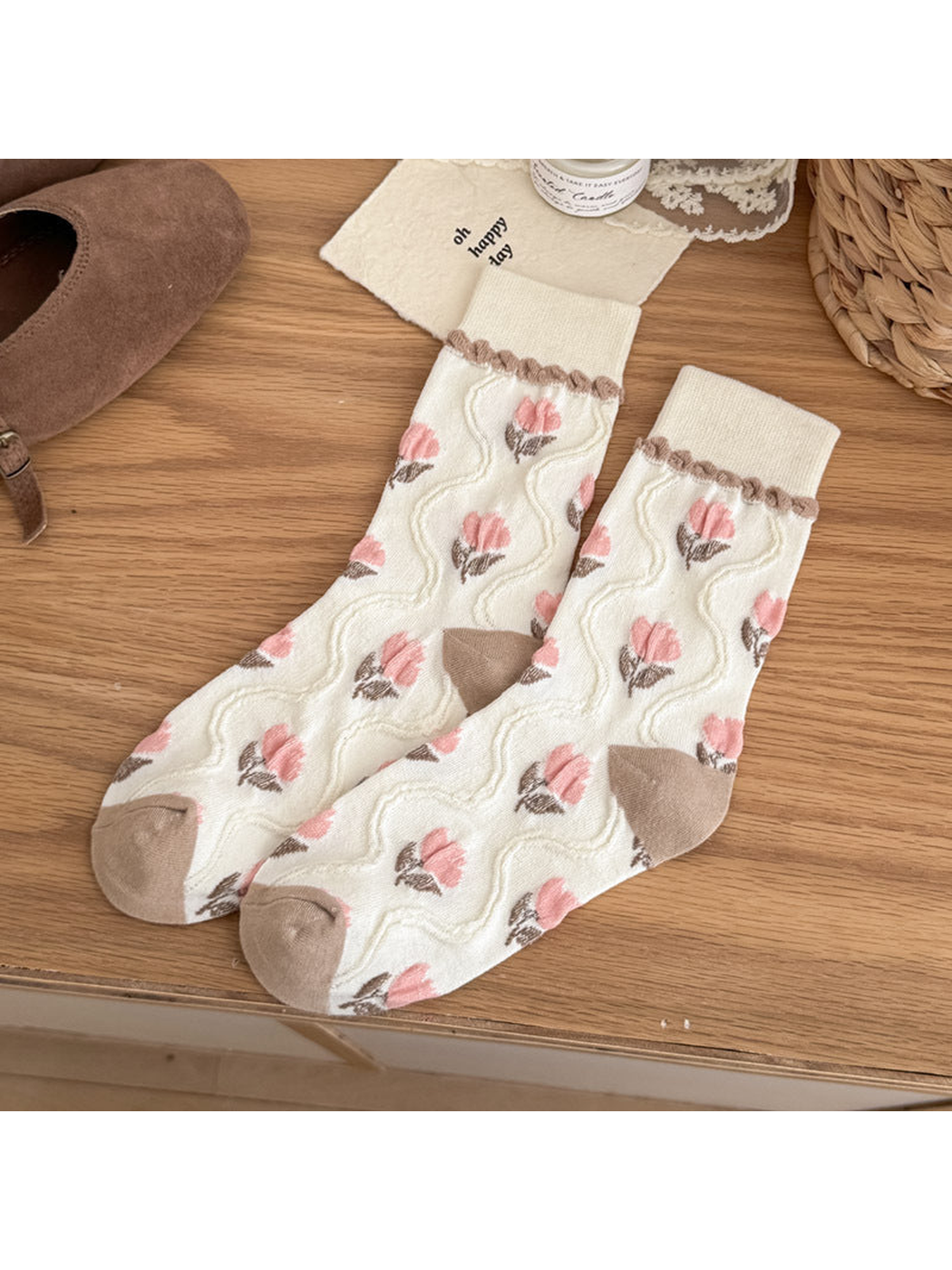 Ivory crew socks with pink tulip motifs, raised wavy lines, and taupe heel and toe panels.