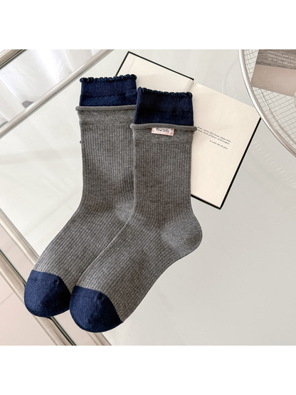 Gray ribbed socks with navy scalloped cuffs and contrasting navy toes