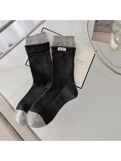 Black ribbed socks with light gray scalloped cuffs and contrasting gray toes